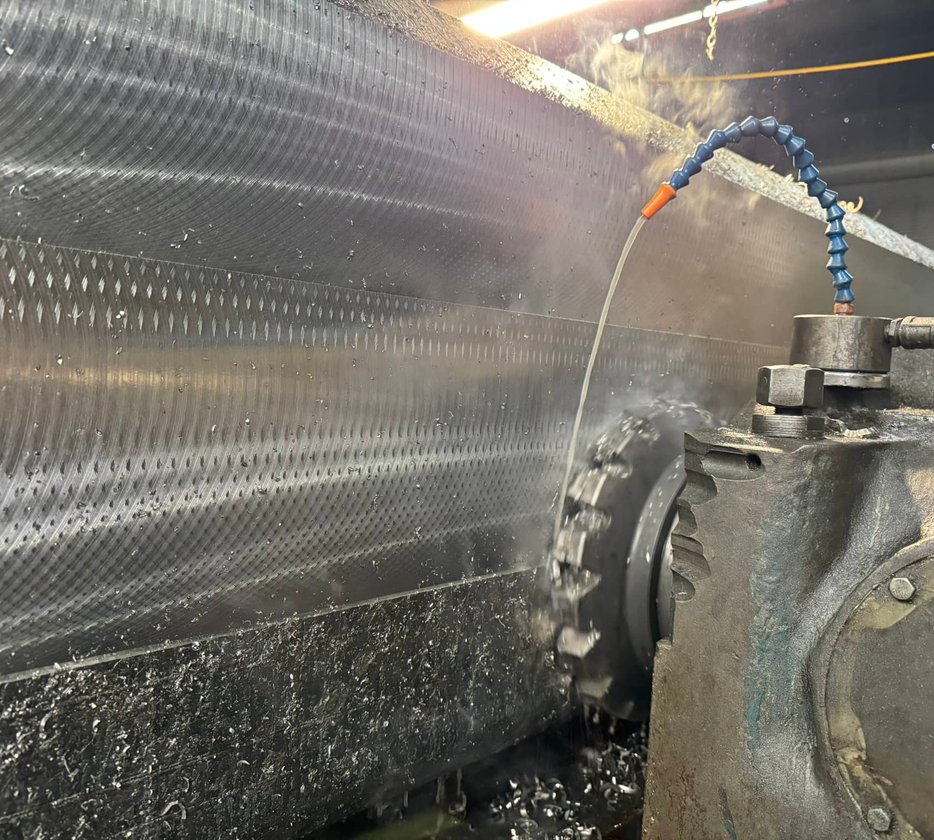 Close-up of bandsaw blade grinding a thick steel plate with sparks