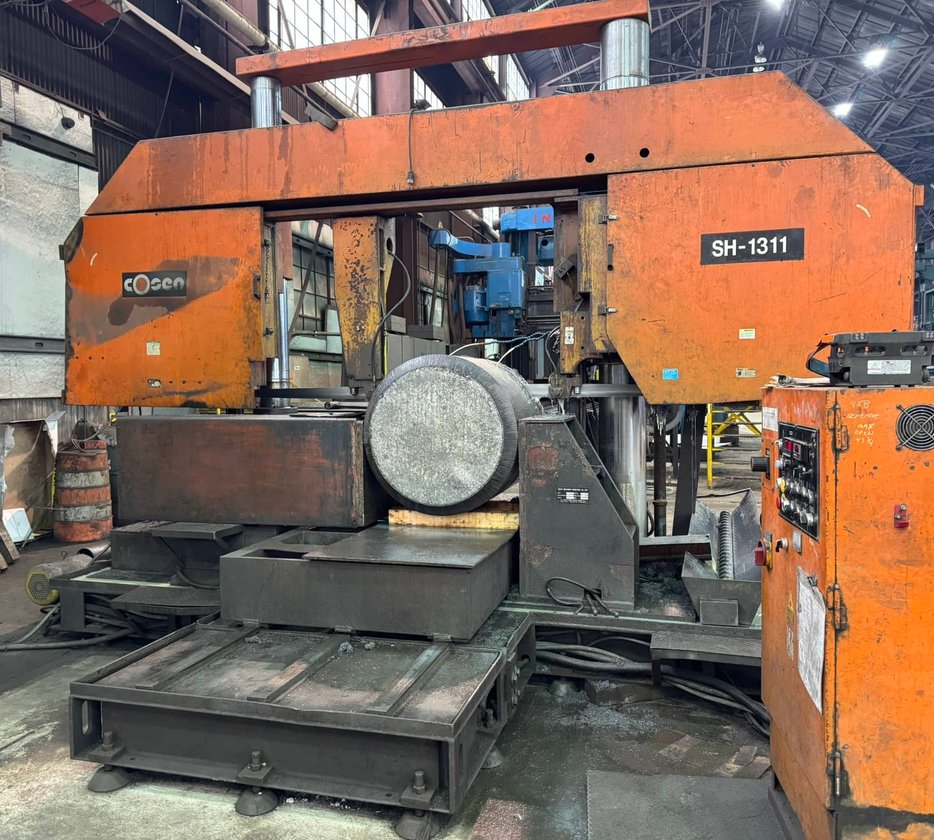 Close-up of a grinding wheel surfacing a polished steel plate with steam